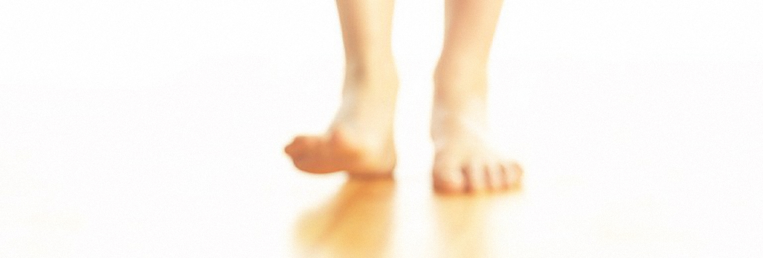 Bare legs walk on a white surface