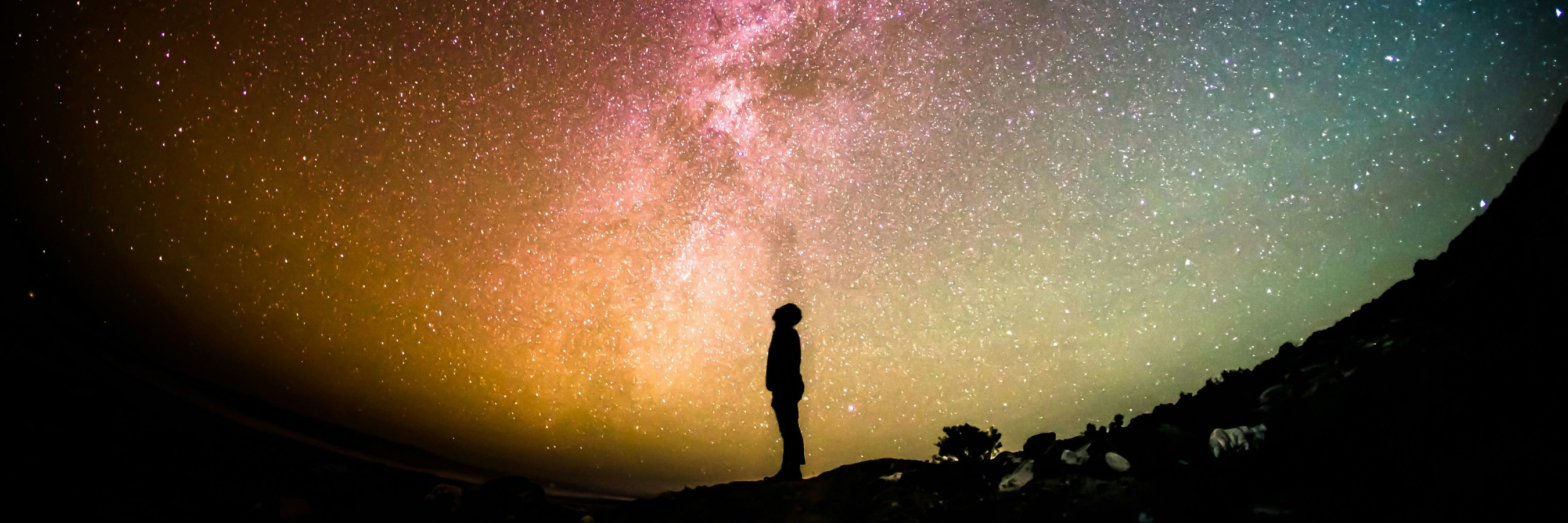 Man standing in silhouette to universe