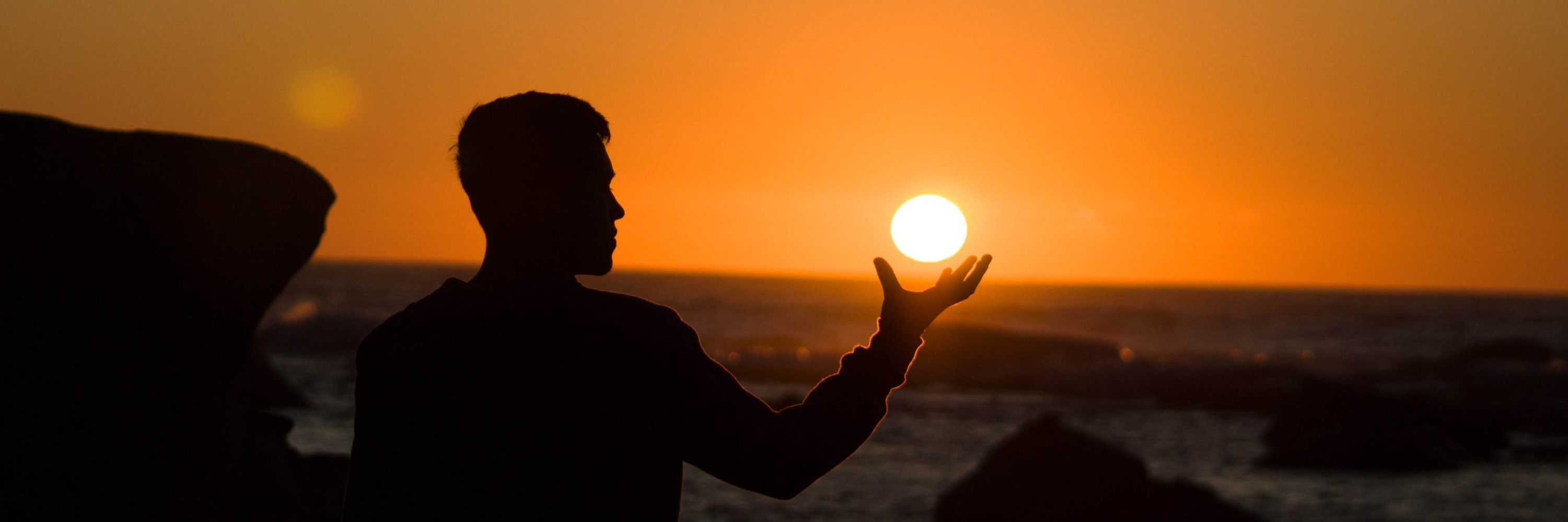 Man in sillouette holds the sun