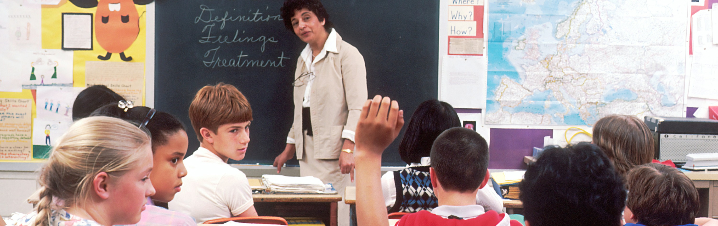 classroom child raises hand to ask of teacher
