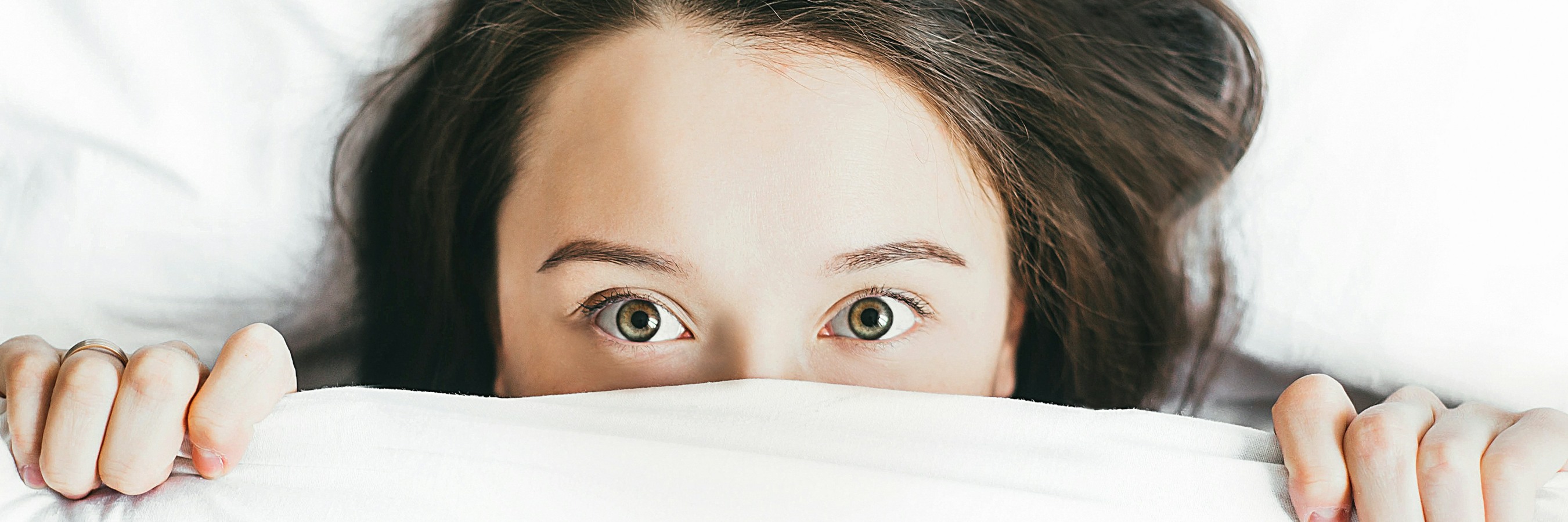 Lady peeking over sheet in surprise